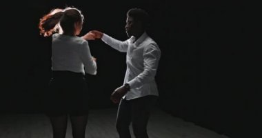 Balo dansı yapan genç bir çift, beyaz tişörtlü bir partner...