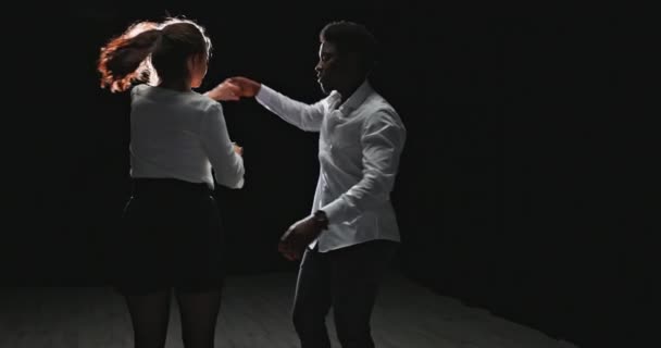 Mladý pár cvičí taneční sál, partner oblečený v bílé košili točí jeho — Stock video