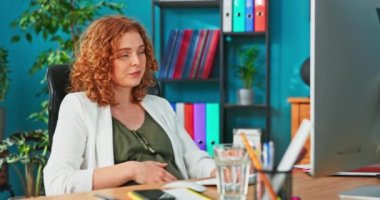 Hamile göbekli bir ofis çalışanı, doğum iznine ayrılmış, bilgisayarın başında oturuyor.,