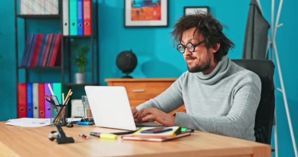 Странный человек работает перед компьютером, пишет письма клиентам, краны на ноутбуке — стоковое видео