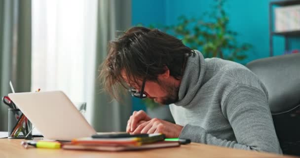 Focused accountant, with serious face, counts companys income on calculator, taps fingers on calculator, calculates, — Stock Video