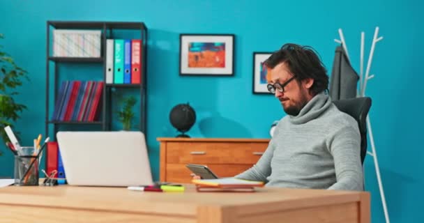 Gek, mentaal onevenwichtig bedrijf werknemer, nerd met ronde, dikke bril, zit op een draaibare stoel in — Stockvideo