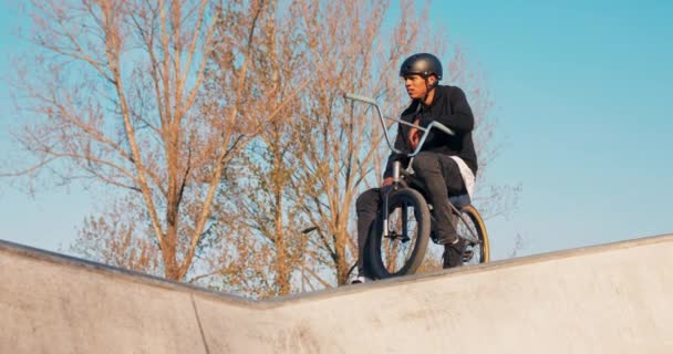 El ciclista se sienta en su humilde bicicleta, un bmx en zapatillas de deporte y ropa suelta con — Vídeos de Stock