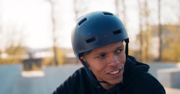 Крупним планом обличчя красивого хлопчика з темним кольором обличчя, сидячи на велосипеді, спираючись на кермо , — стокове відео
