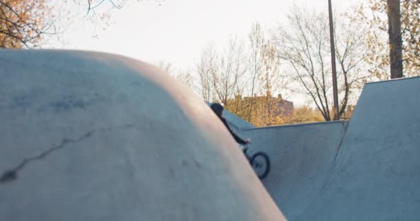 Professional, stunt, cyclist, handsome boy dressed in loose clothing, rides bmx up ramp, leaning wall, — Stock Video