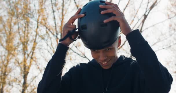 A young boy is sitting on a ramp at a skatepark, smiling, happy. The boy — Stock Video