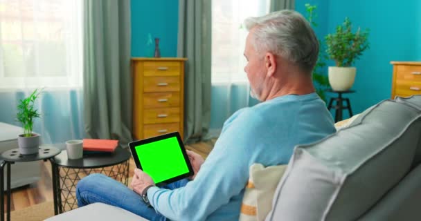 Old Man at Home verwendet grüne Bildschirmmotive. Er sitzt auf einer Couch — Stockvideo