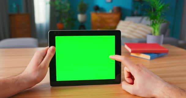 Man Holding en het gebruik van handbewegingen op Green Mock-up Screen Digital Tablet Computer tijdens het zitten — Stockvideo
