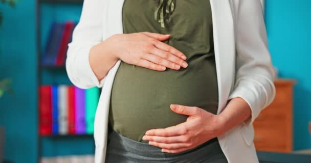Närbild av gravid mage som smeks av kvinnor händer, skjuten med ansiktet av vackra, representativa — Stockvideo