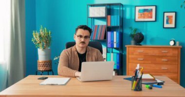 CEO, şirket yöneticisi, ortak sahibi bir dizüstü bilgisayarın önünde oturuyor.