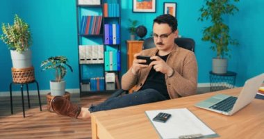 Gözlüklü yakışıklı bir ofis çalışanı iş yerinde tembeldir, görevlerini yerine getirmez,