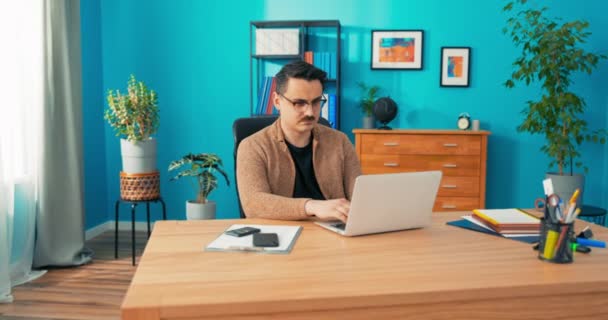 Facet w okularach siedzi w biurze firmy przed komputerem sprawdzając konto bankowe, płatności — Wideo stockowe