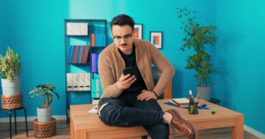 Gözlüklü bir adam, şirket başkanı, yönetici onunla birlikte masanın üstünde oturuyor.