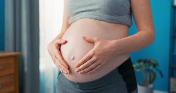 Zbliżenie brzucha ładnej kobiety w zaawansowanej ciąży, ostatni trymestr ciąży, ubrana w strój domowy — Wideo stockowe