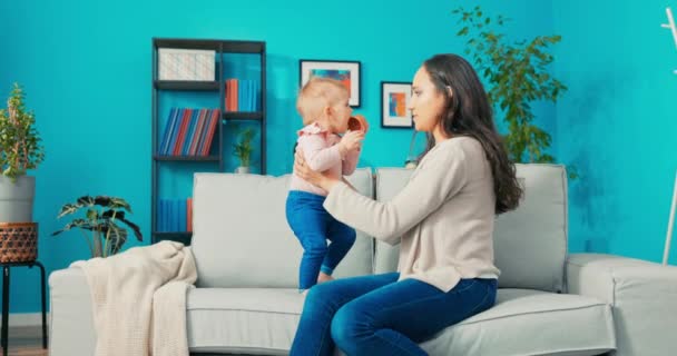 Felelős anya ül a kanapén a gyermek, veszi elé, és teszi őt — Stock videók