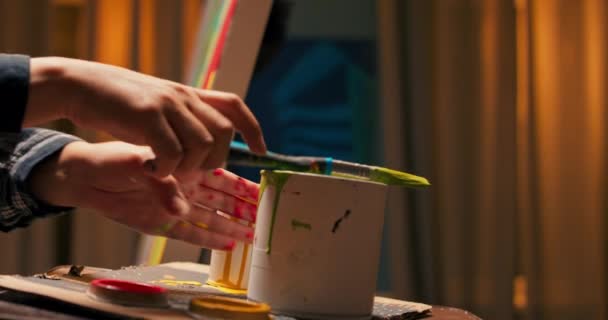 Ujęcie puszki farby stojącej na stole przy sztaludze, brudnej — Wideo stockowe