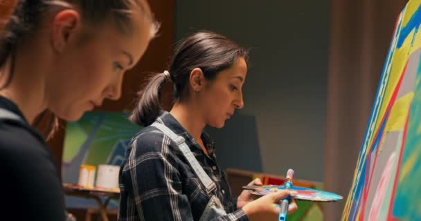 Des amis jouent dans le studio de peinture ensemble, passant du temps à créer un chef-d'œuvre avec des peintures acryliques, — Video