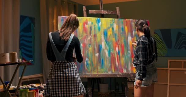 Талановиті дівчата проводять вільний вечір у художній студії, стоячи перед — стокове відео