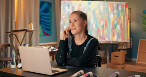 才能のあるアーティストは、絵画スタジオに座って、ノートパソコンの画面の前に保存し、上の話 — ストック動画