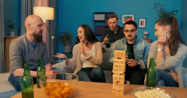 Kusiner tillbringar familjens tid på kvällen, äter chips dricker öl, tittar på komedier, leker — Stockvideo
