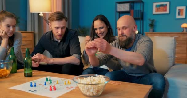 Лиса людина з бородою сидять на дивані з друзями вони грають настільні ігри ввечері, — стокове відео