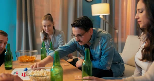 Hombre con gafas pasa la noche en la sala de estar con amigos, juegan juegos de mesa chico — Vídeos de Stock