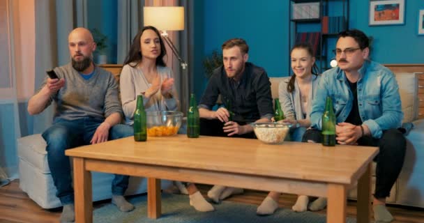 Pięciu dobrych przyjaciół spędza wieczór w swoim towarzystwie siedząc na kanapie i żyjąc — Wideo stockowe