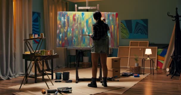 Artista donna sta dipingendo un dipinto ad olio astratto, lei sta guardando i risultati di — Video Stock