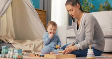 Çekici bir kadın oğluyla evde vakit geçiriyor. Birlikte yerde oturup oyun oynuyorlar.