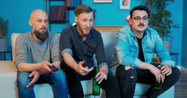 Üç arkadaş oturma odasında kanepede dinleniyor, birbirleriyle konuşuyorlar.,