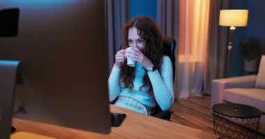 İşten sonra yorgun düşen genç kız akşamları bilgisayarın başına oturur.