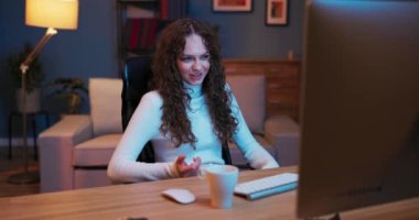 Çekici kadın akşamları dizüstü bilgisayarın önünde gevşer ve video sohbetleriyle vakit geçirir.