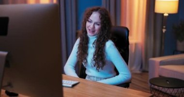 Çekici kadın akşamları dizüstü bilgisayarın önünde gevşer ve video sohbetleriyle vakit geçirir.