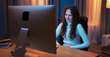 Çekici kadın akşamları dizüstü bilgisayarın önünde gevşer ve video sohbetleriyle vakit geçirir.