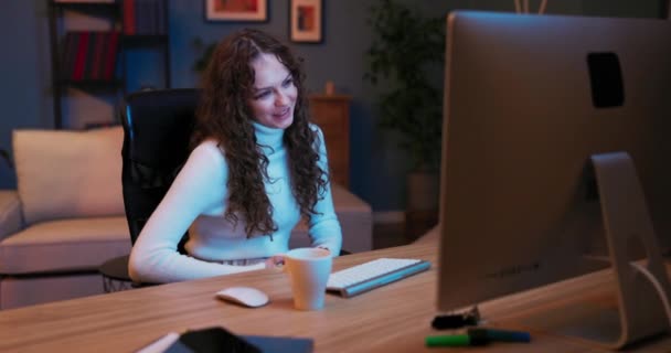 Mujer atractiva se relaja en la noche delante de la pantalla del ordenador portátil, pasa el tiempo de chat de vídeo sobre — Vídeos de Stock