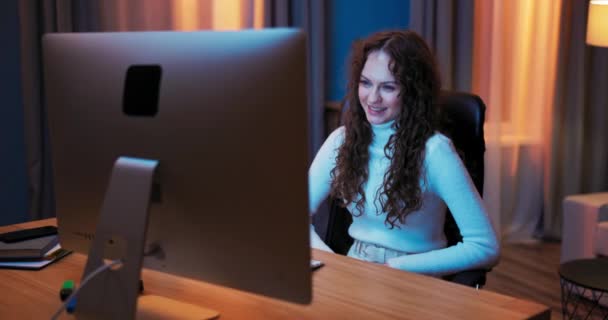 Belle femme se détend le soir devant l'écran de l'ordinateur portable, passe du temps à bavarder vidéo sur — Video