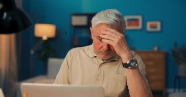 Yorgun, çökmüş, istifa etmiş, dalgın yaşlı bir adam dizüstü bilgisayarın, bilgisayarın ve