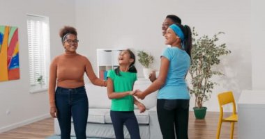 Çocuklu genç ebeveynler satın alınmış daireye taşınıyorlar, etrafa bakınıyorlar, içlerine hayranlık duyuyorlar, mutlu kızları kucaklıyorlar, annelerini kucaklıyorlar, baba büyük kızı kucaklıyor, birlikte yer değiştiriyorlar.