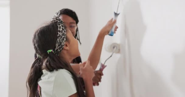 Mamá pasa tiempo con su hija, juntos pintan paredes en un apartamento renovado, aplicando — Vídeo de stock