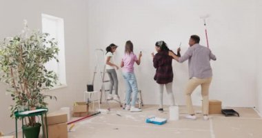 Deli aile duvarları beyaz boyayla boyarlar, ortasında dans ederler.