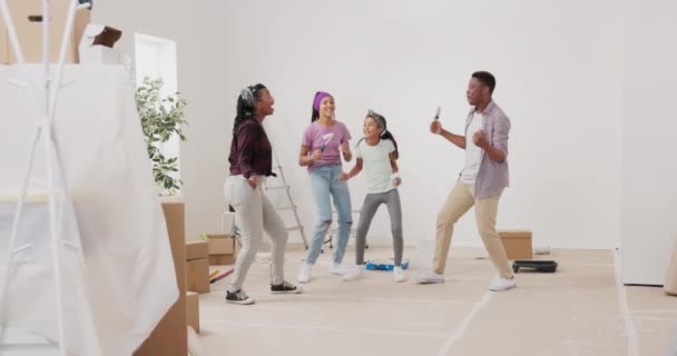 Loco familia feliz pintando las paredes con pintura blanca con pinceles, bailan en el — Vídeo de stock