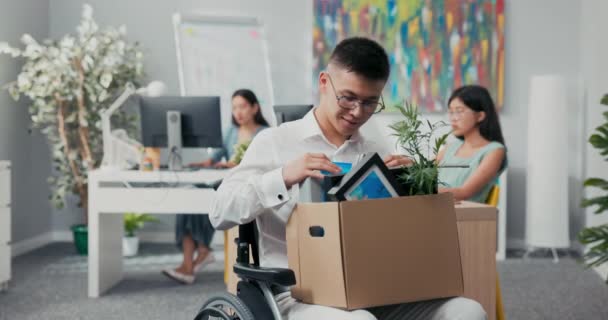 Sonriente, hombre alegre en gafas es discapacitado monta silla de ruedas por esta razón obtiene una promoción — Vídeo de stock