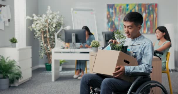Чоловік-інвалід, одягнений у сорочку, отримав роботу в офісі супутників він сидить у інвалідному кріслі — стокове відео
