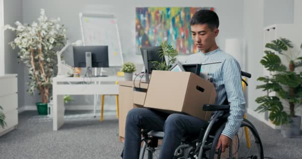 Disabled ambitious man in shirt with Asian Korean beauty sits in wheelchair at desk in
