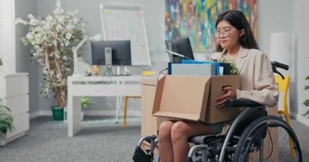 Gehandicapte vrouw met bril en Aziatische Koreaanse schoonheid zit in een rolstoel aan corporate bureau op — Stockvideo