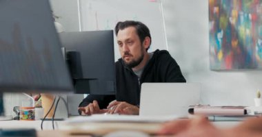 Memnuniyet duyan ofis çalışanı bilgisayar monitörünün önünde oturmuş terfi almaktan mutluluk duyuyor.