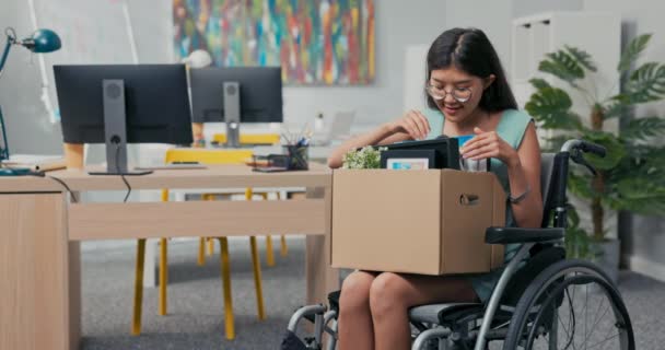 Sonriendo a las mujeres jóvenes con gafas está discapacitada ella está en una silla de ruedas y debido a — Vídeo de stock