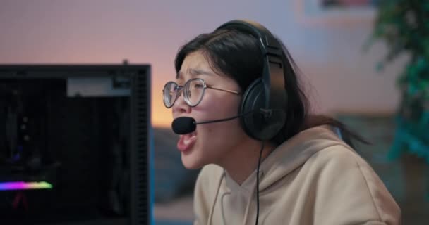 Професійний геймер втрачає великі гроші в онлайн-комп'ютерній грі, жінка в гарнітурі кричить членам команди, плаче, ламається, дискваліфікується з онлайн-конкурсу, махає руками в гніві — стокове відео
