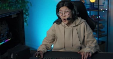 Profesyonel oyuncu kadın eSports atıcı video oyunları ve büyük bir bilgisayar ekranında modern grafikler. Sanal oyun odası. Mavilerle aydınlatılmış.