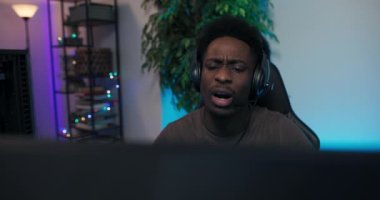 Adam bilgisayar oyununu kaybediyor, monitörde hayal kırıklığına uğruyor, kulaklıkla takıma konuşuyor, yüzünü ellerle kapatıyor, arkadaşlarını rahatlatıyor. Oyuncu gecelerini ışıklarla aydınlatılmış bir odada geçirir.